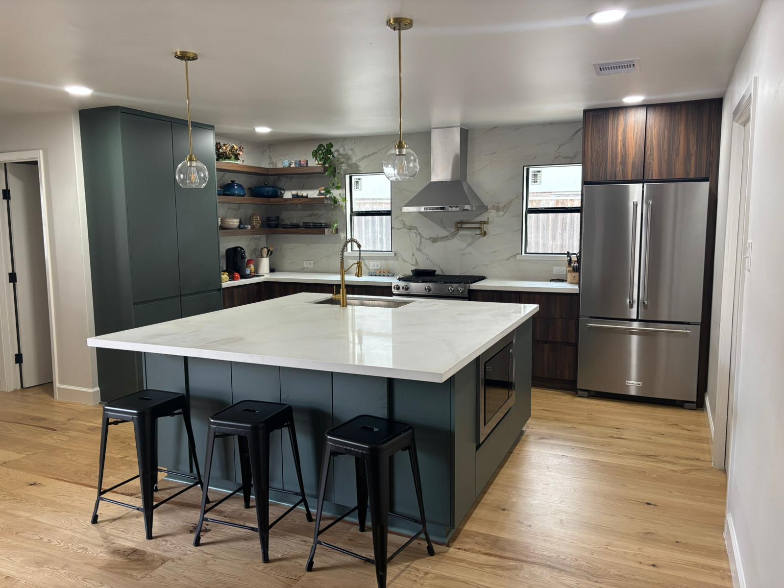 Custom Oak Forest kitchen with wood cabinets, marble backsplash, island cooktop, and built-in wall appliances